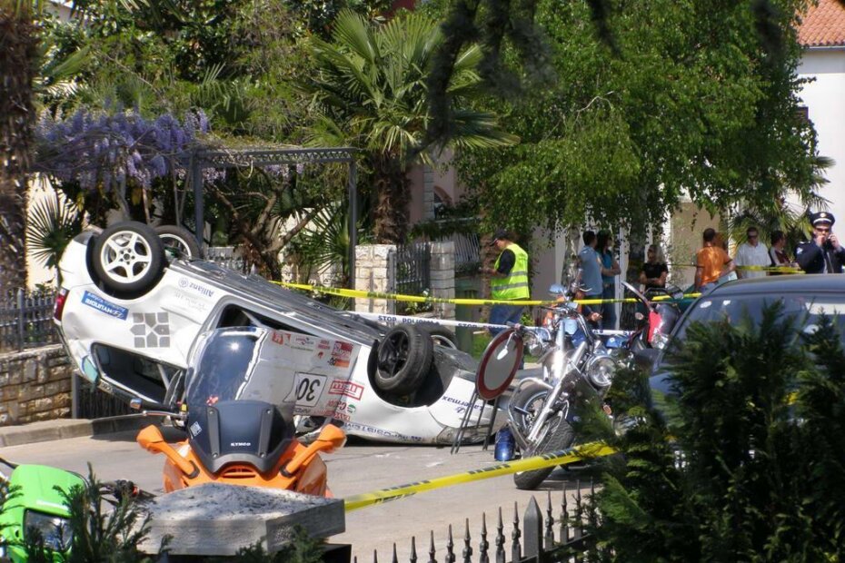 Prevrnuti bolid među gledateljima i motociklima