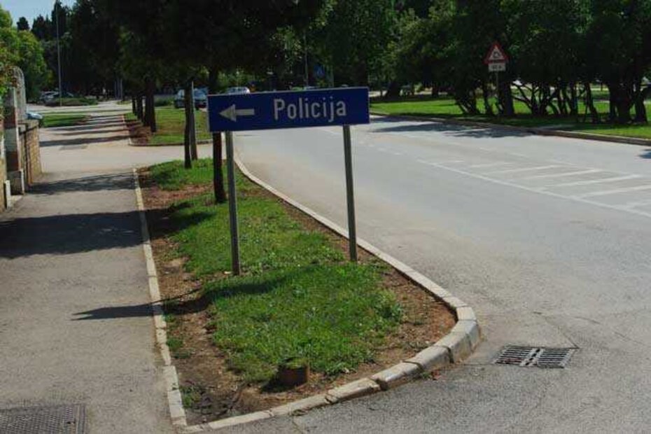 Iz ulice u kojoj je smještena policijska postaja (Gimnastička) izaći se može samo pokraj ovoga znaka. Pogled ulijevo zatvara putokaz u visini vozačevih očiju.