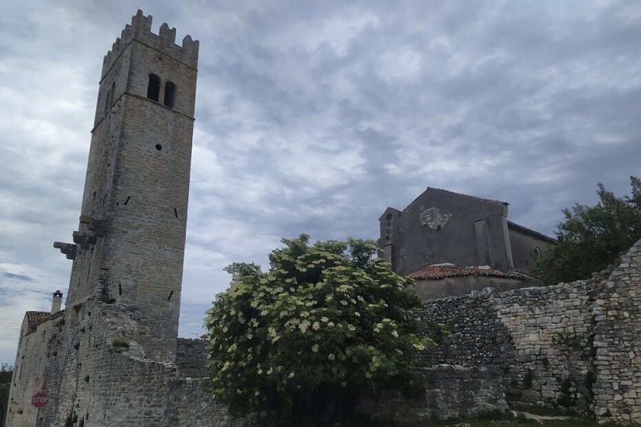Lovrečki zvonik-kula uklopljen je u pojas zidina; na fotografiji je vidljivo i začelje župne crkve Sv. Martina iz prve polovice 11. stoljeća